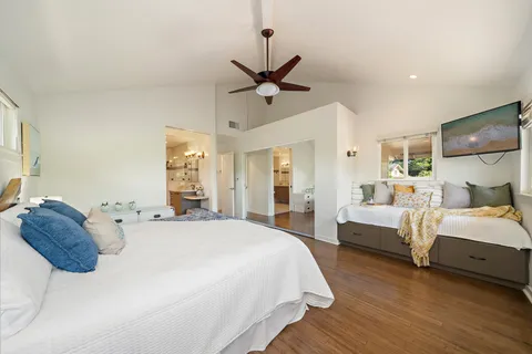 a spacious bedroom with a bed and ceiling fan