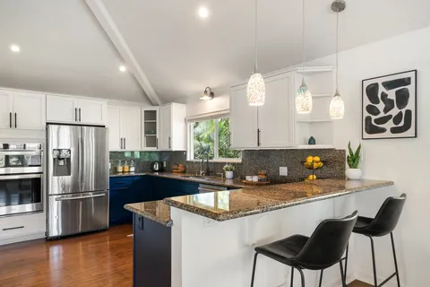 a kitchen with stainless steel appliances granite countertop a sink refrigerator and cabinets