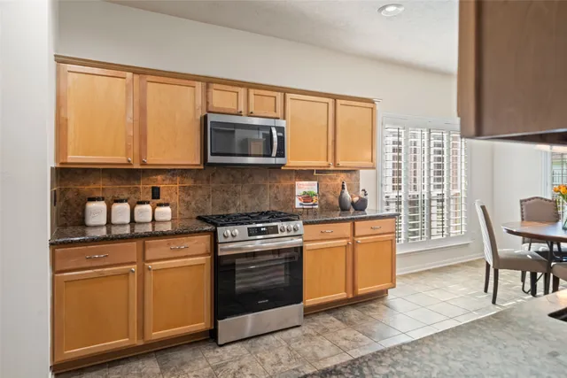 a kitchen with stainless steel appliances kitchen island granite countertop a sink and cabinets