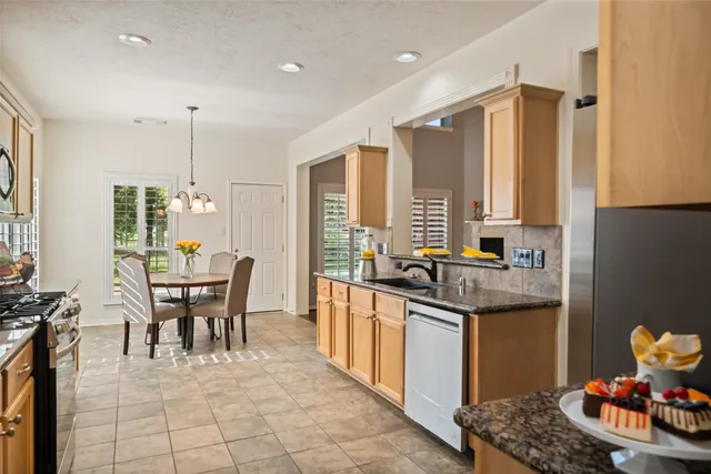 a living room with furniture kitchen view and a chandelier