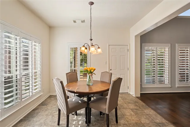 a view of a dining room and livingroom with furniture wooden floor a chandelier