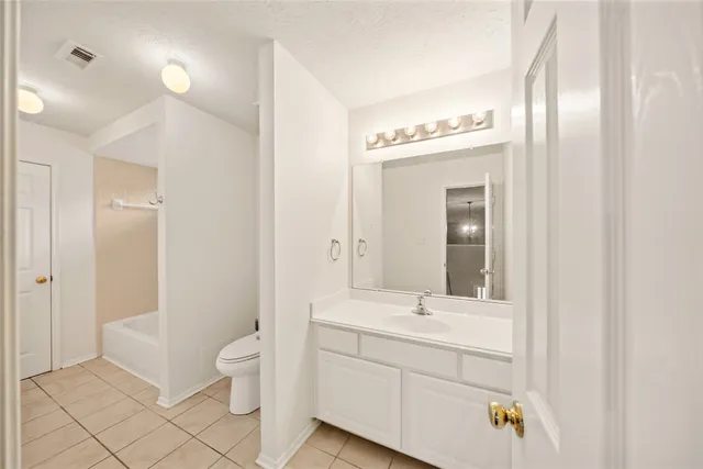a bathroom with a granite countertop sink a mirror and a bathtub