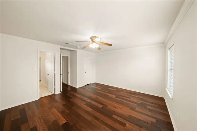 an empty room with windows and fan