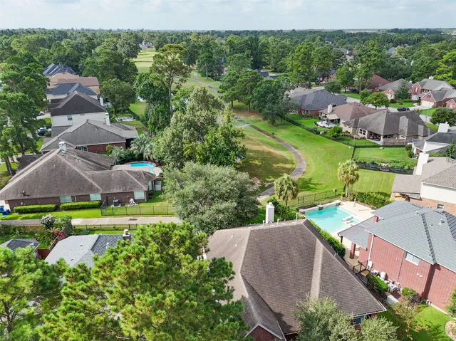 an aerial view of residential houses with outdoor space and trees all around