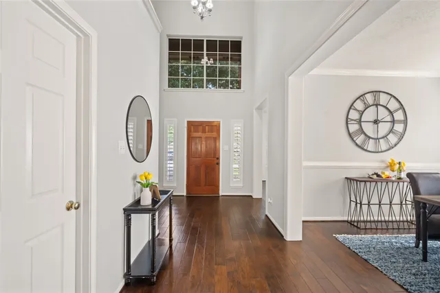 a view of a dining room with furniture a chandelier and wooden floor