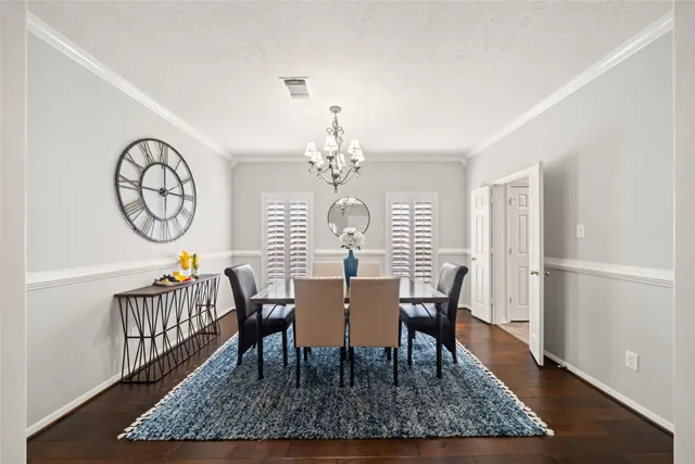 a view of a dining room with furniture a chandelier and wooden floor
