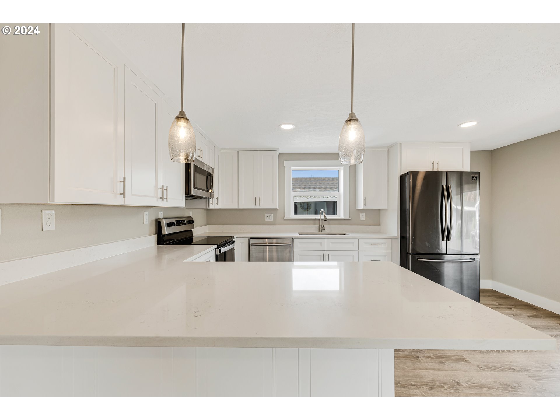 32968 Southwest Plum Tree Court Cornelius, OR 97113 - Photo 16 of 30 a kitchen with stainless steel appliances kitchen island granite countertop a refrigerator a stove a sink dishwasher and white cabinets with wooden floor