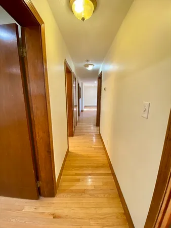 a view of a hallway with wooden floor