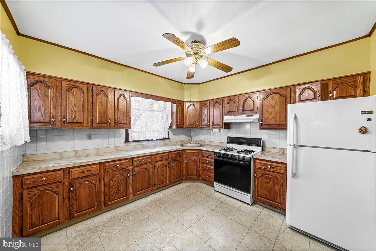 217 Avon Road Upper Darby, PA 19082 - Photo 7 of 16 a kitchen with stainless steel appliances granite countertop cabinets and a refrigerator