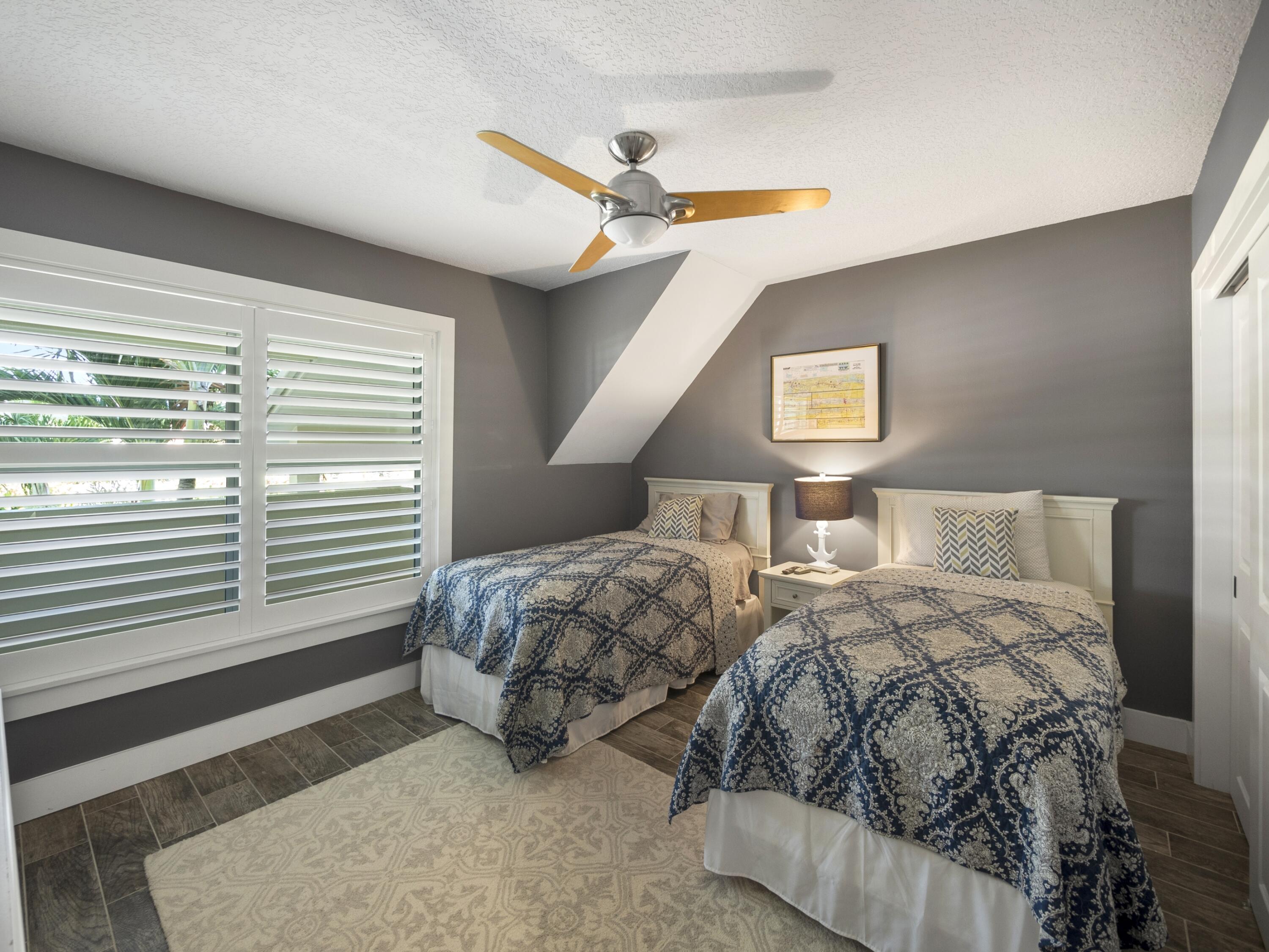 4161 U.S. Highway 1, Unit C3 Jupiter, FL 33477 - Photo 22 of 34 a bedroom with two beds and a chandelier