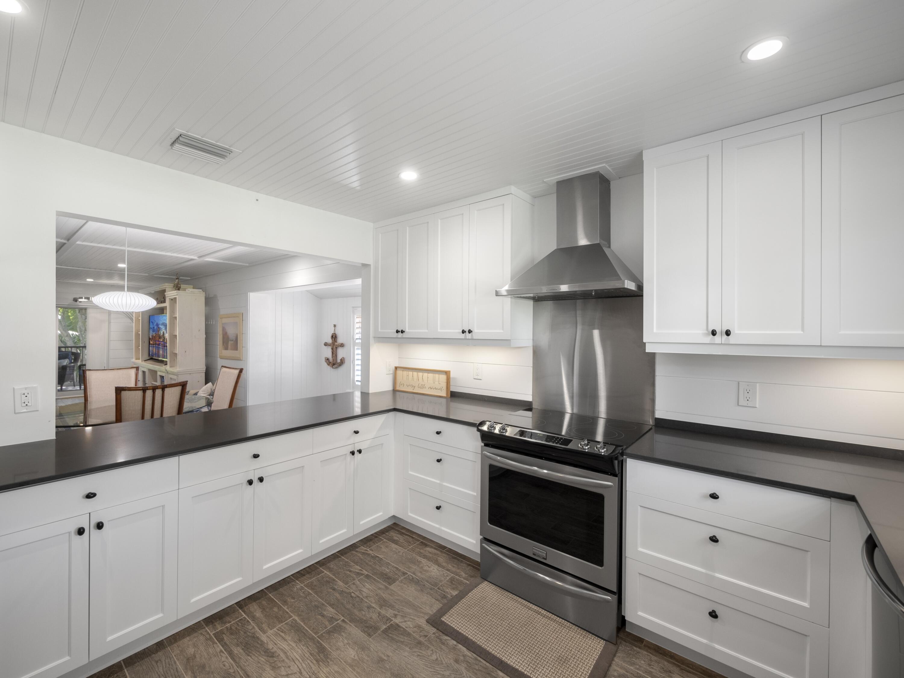 4161 U.S. Highway 1, Unit C3 Jupiter, FL 33477 - Photo 9 of 34 a kitchen with white cabinets and appliances