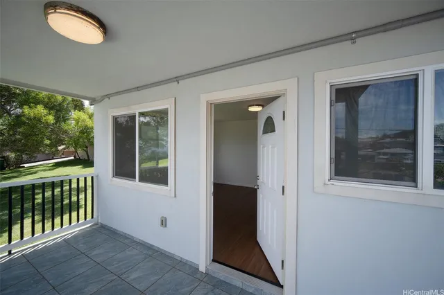 an entryway with wooden floor and windows