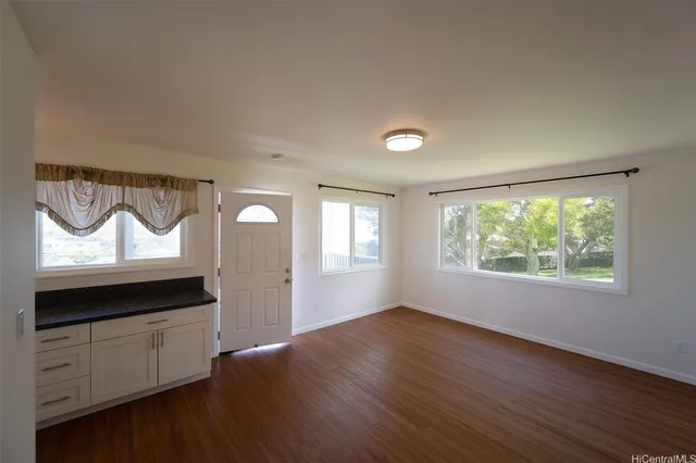 a view of empty room with wooden floor and window