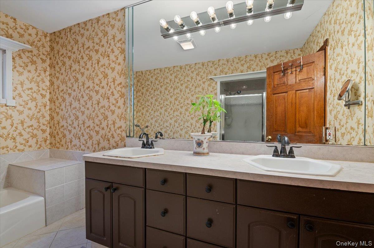 33 Fleets Cove Road Huntington, NY 11743 - Photo 23 of 42 Full bath with double vanity, a shower stall, a bath, wallpapered walls, and light tile patterned floors