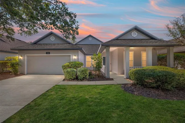 a front view of a house with a yard and potted plants