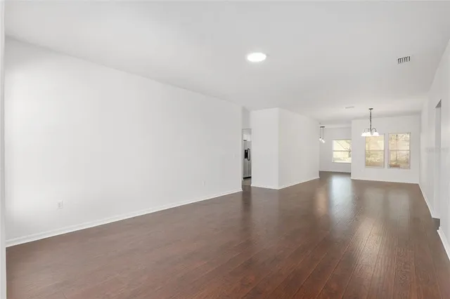 an empty room with wooden floor and window