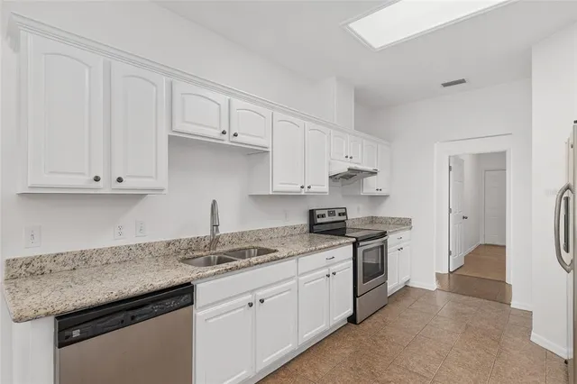 a kitchen with granite countertop a sink white cabinets and a granite counter tops