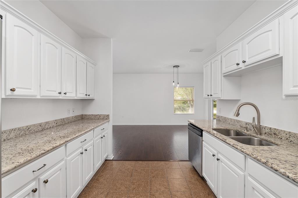 7982 Southwest 83rd Terrace Gainesville, FL 32608 - Photo 18 of 53 a kitchen with granite countertop a sink white cabinets and a granite counter tops