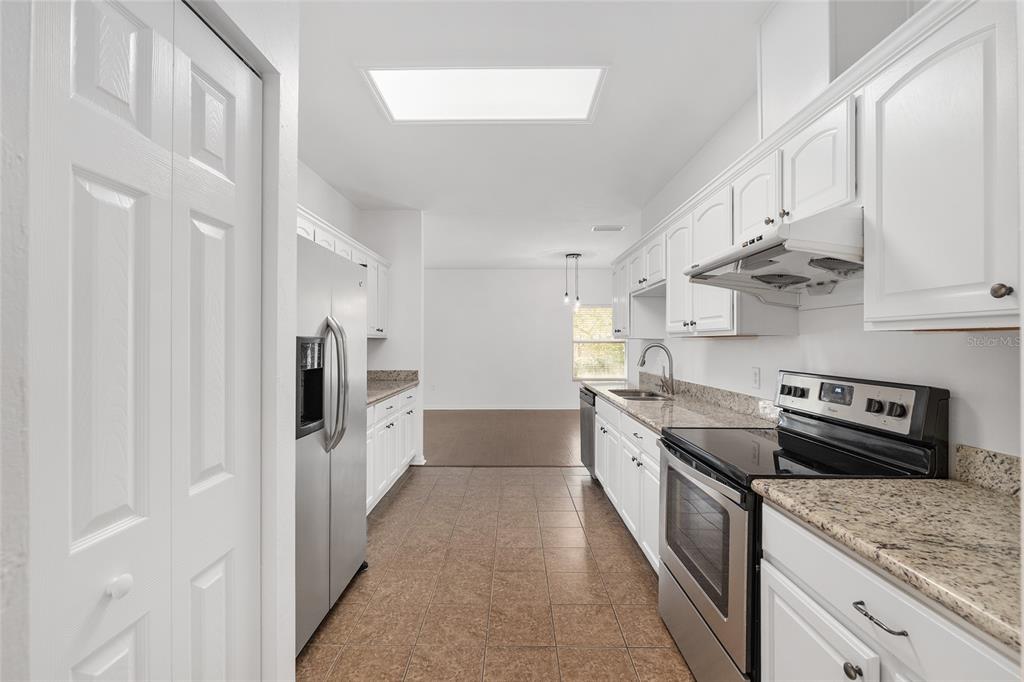 7982 Southwest 83rd Terrace Gainesville, FL 32608 - Photo 21 of 53 a kitchen with stainless steel appliances granite countertop a refrigerator a stove and a sink