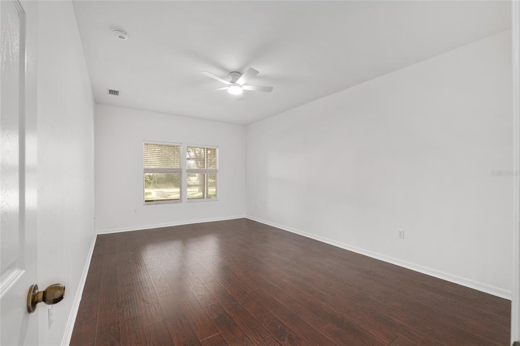 7982 Southwest 83rd Terrace Gainesville, FL 32608 - Photo 22 of 53 an empty room with wooden floor and windows