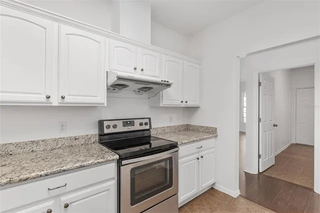 a kitchen with stainless steel appliances granite countertop a refrigerator a stove and a sink