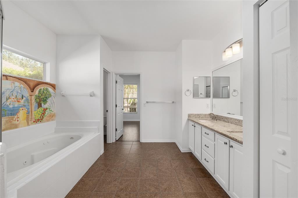 7982 Southwest 83rd Terrace Gainesville, FL 32608 - Photo 27 of 53 a bathroom with a granite countertop tub a sink and a shower