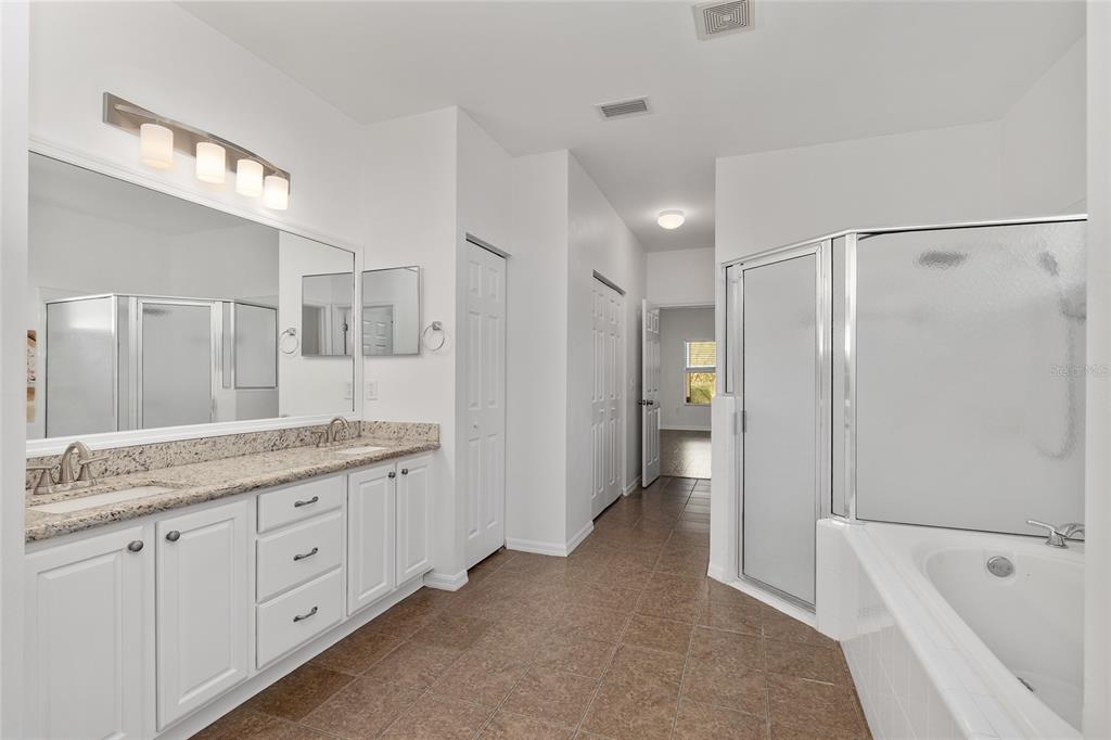 7982 Southwest 83rd Terrace Gainesville, FL 32608 - Photo 29 of 53 a bathroom with a granite countertop sink a large mirror and shower