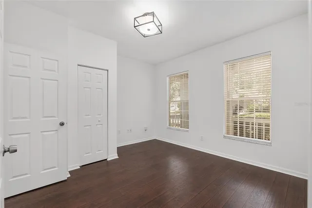a view of a hallway with wooden floor and closet