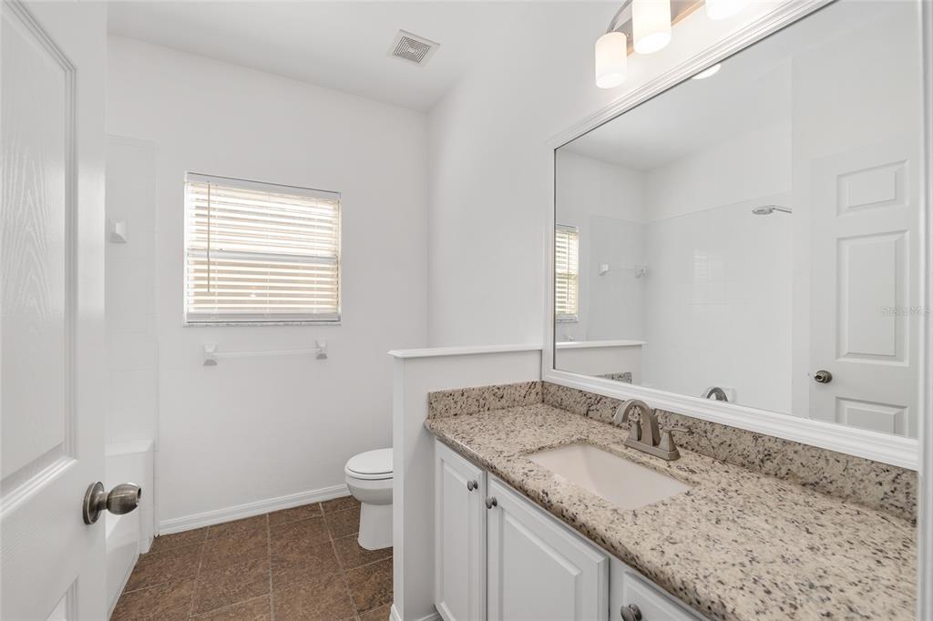 7982 Southwest 83rd Terrace Gainesville, FL 32608 - Photo 38 of 53 a bathroom with a granite countertop sink and mirror with window