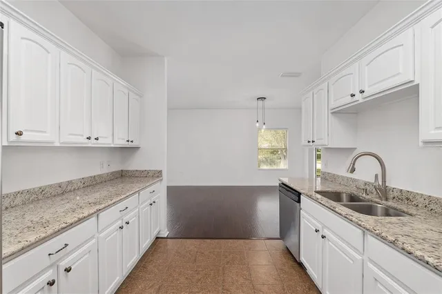 a kitchen with granite countertop a sink white cabinets and a granite counter tops