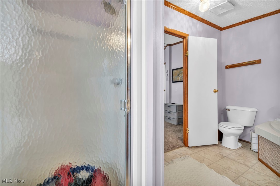 27202 Cook Road, Unit 95 Olmsted Falls, OH 44138 - Photo 26 of 46 Full bath with a stall shower, ornamental molding, and light tile patterned floors