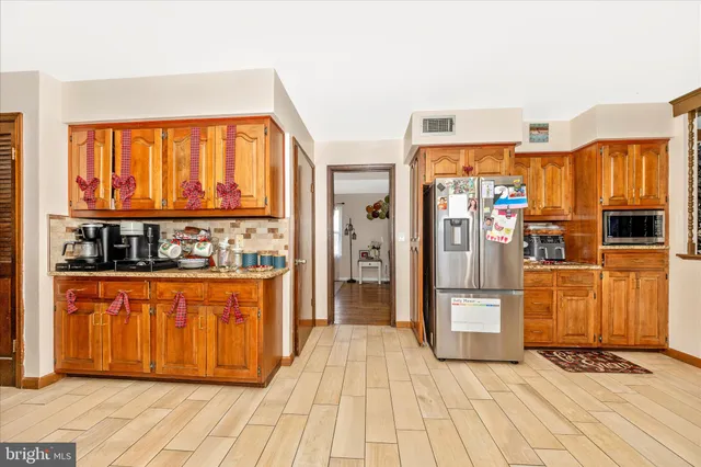 a kitchen with stainless steel appliances granite countertop a stove and a wooden floors