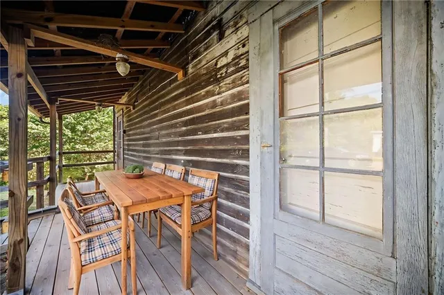 a view of a backyard with table and chairs with wooden floor and fence