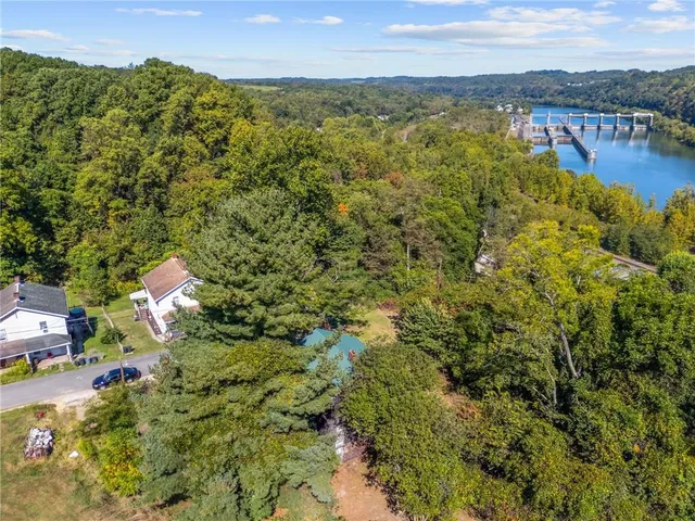 a wooden house with a bench in the forest