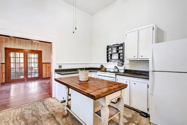 a kitchen with granite countertop a stove a refrigerator and a sink