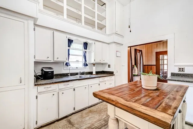 a kitchen with white cabinets and sink