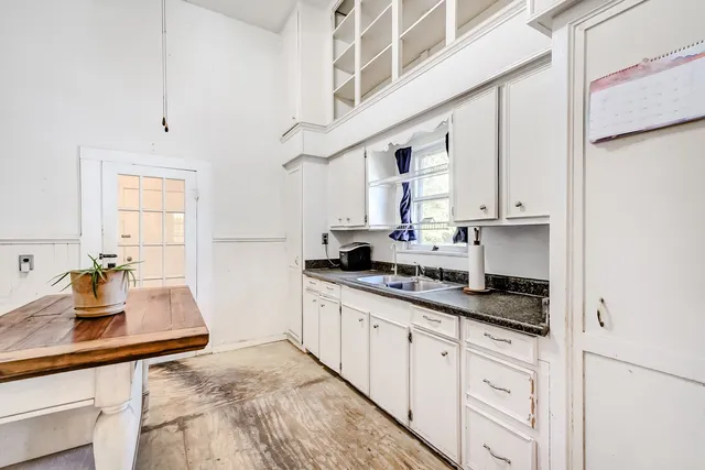 a kitchen with stainless steel appliances granite countertop a sink a stove and white cabinets