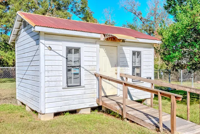 a view of a house with a small yard and wooden fence