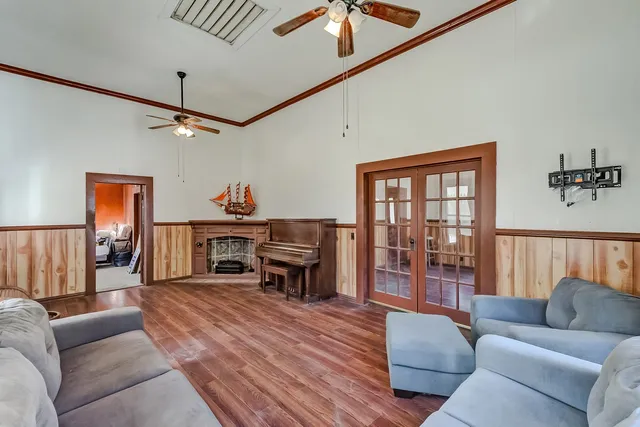 a living room with furniture a ceiling fan and a wooden floor
