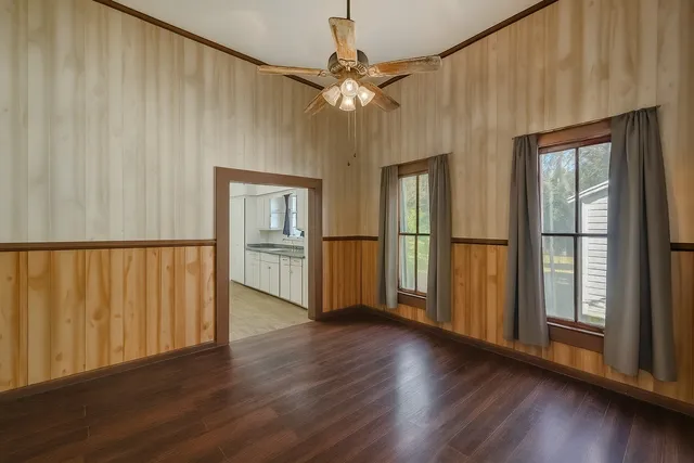 a view of a big room with wooden floor fan and windows