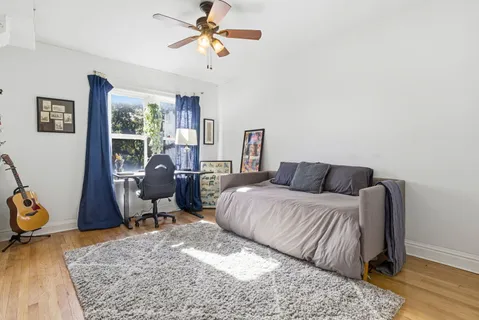 a bed room with a bed a chair and a potted plant