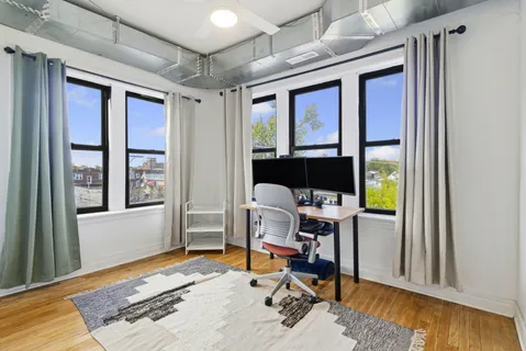 a view of a livingroom with workspace and a window