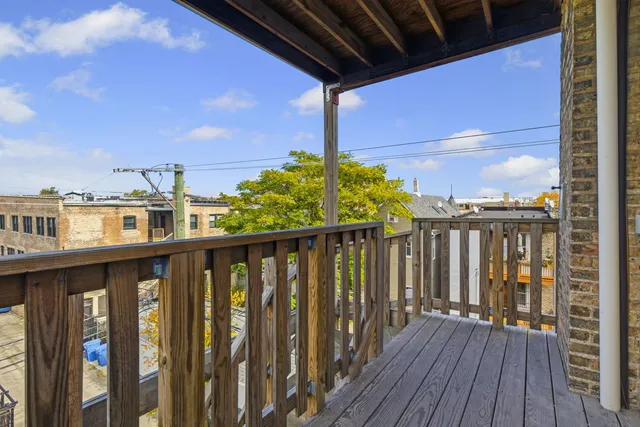 a balcony with wooden floor and city view