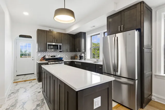 a kitchen with kitchen island a counter appliances and cabinets
