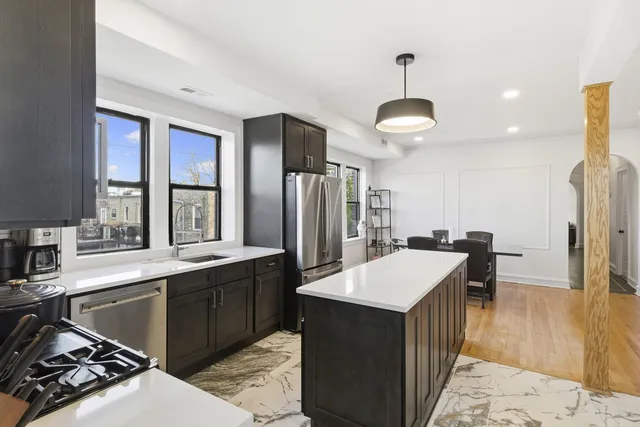 a kitchen with kitchen island a sink stove and refrigerator