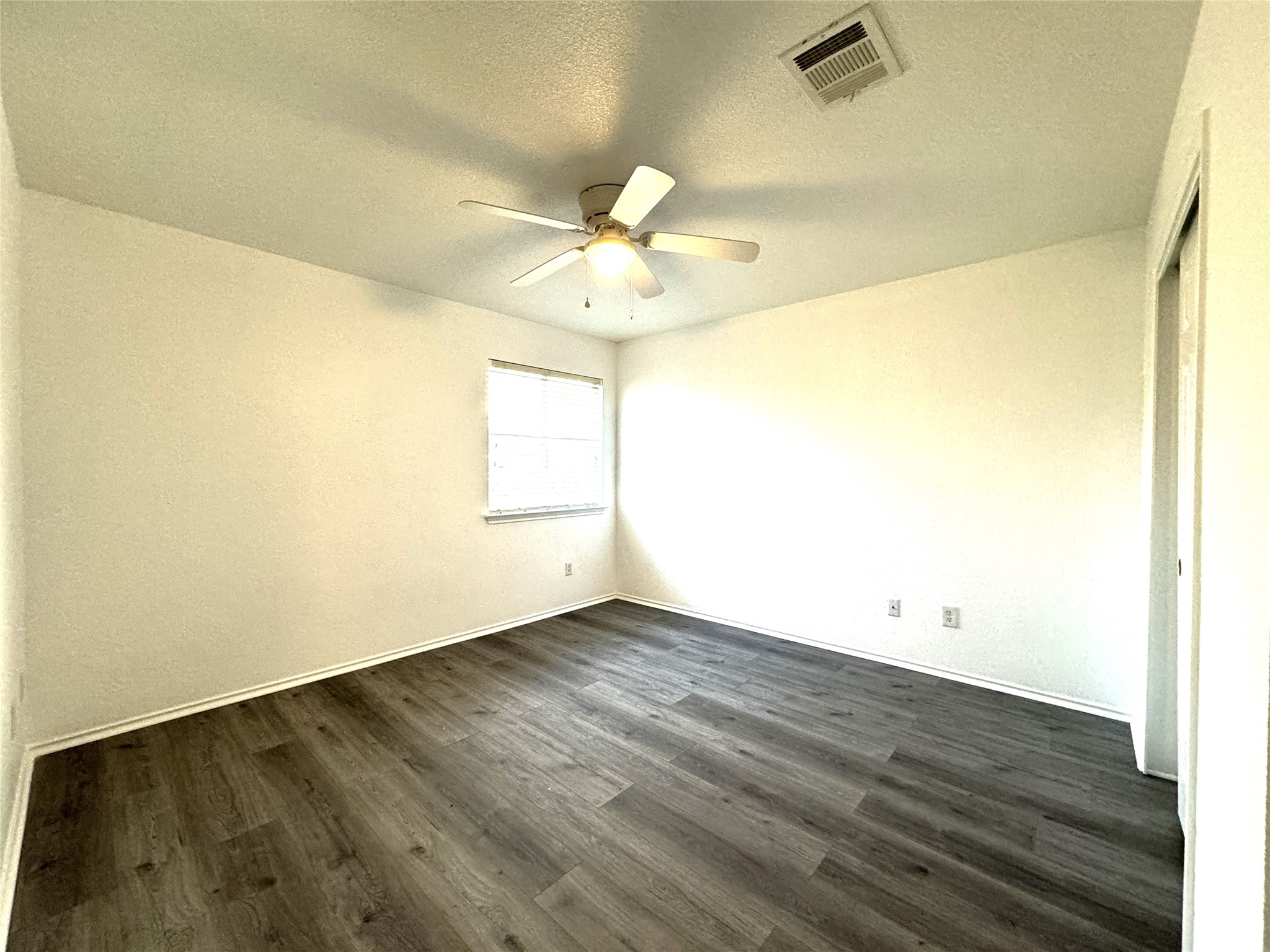 115 Killian Loop Hutto, TX 78634 - Photo 11 of 14 A quiet bedroom with robust laminate flooring and a ceiling fan, offering a serene personal space.