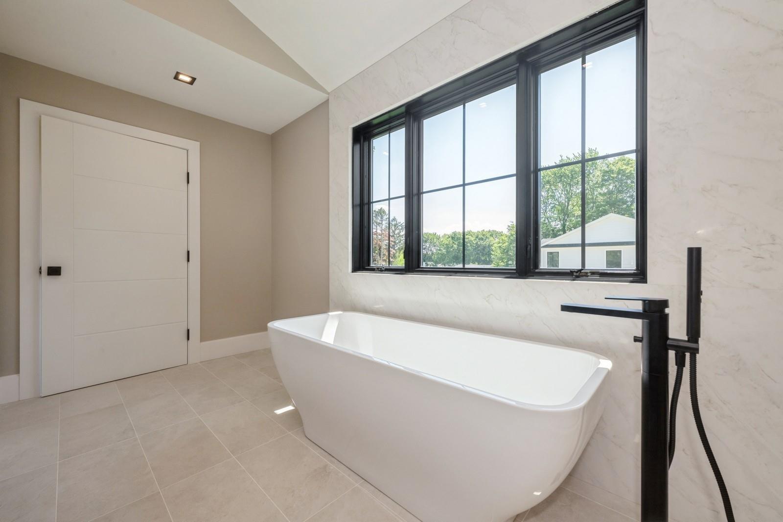 352 Cold Spring Road Syosset, NY 11791 - Photo 29 of 39 a white bath tub sitting in a bathroom next to a window