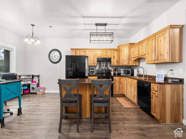 40 Ginger Gold Road Santaquin, UT 84655 - Photo 5 of 32 Kitchen featuring wood cabinetry, dark countertops, black appliances, a central island, and wood-finish flooring