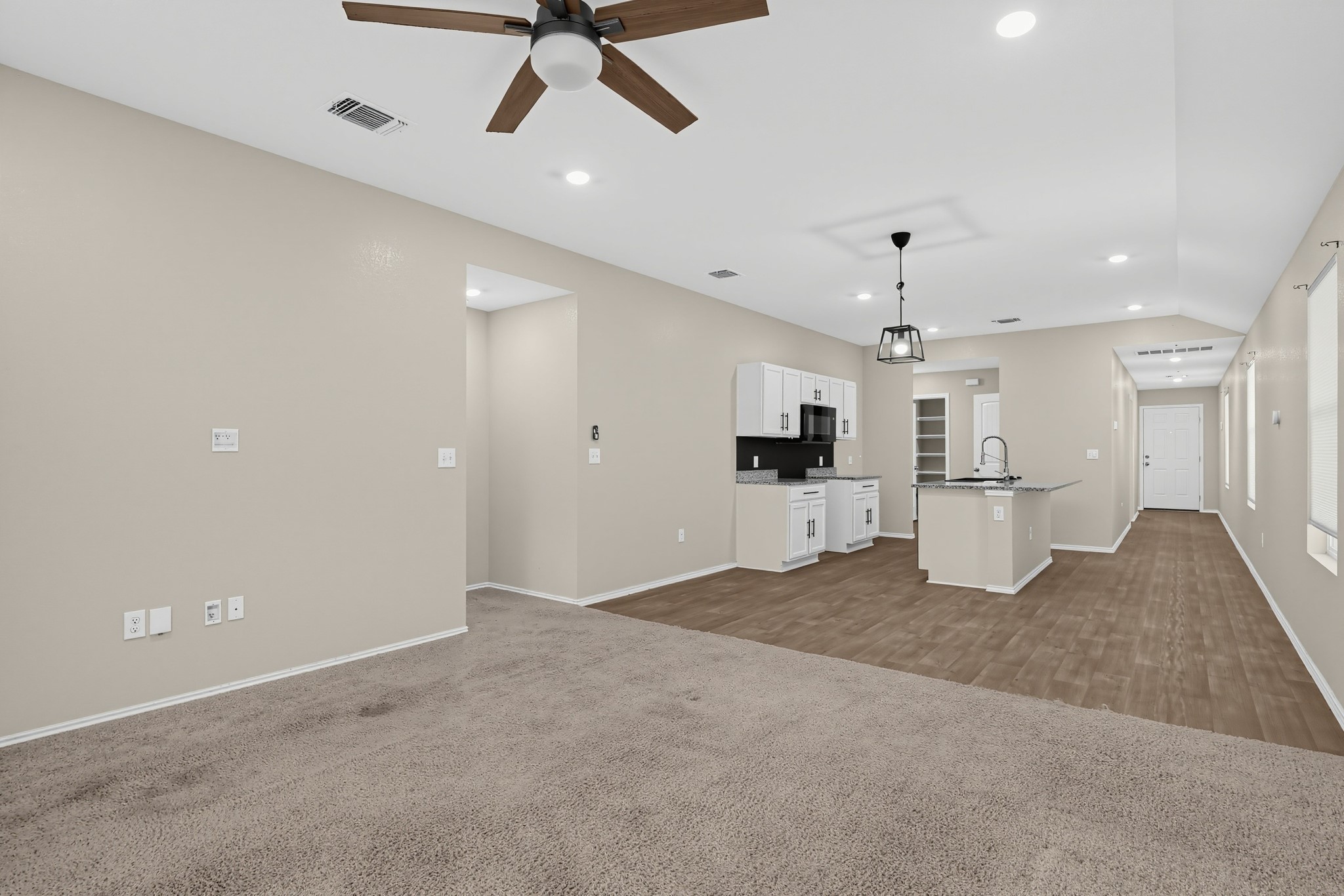 11810 Pyrite Road Manor, TX 78653 - Photo 38 of 38 An open floorplan seamlessly connects the carpeted living area to the wood-look flooring of the kitchen.