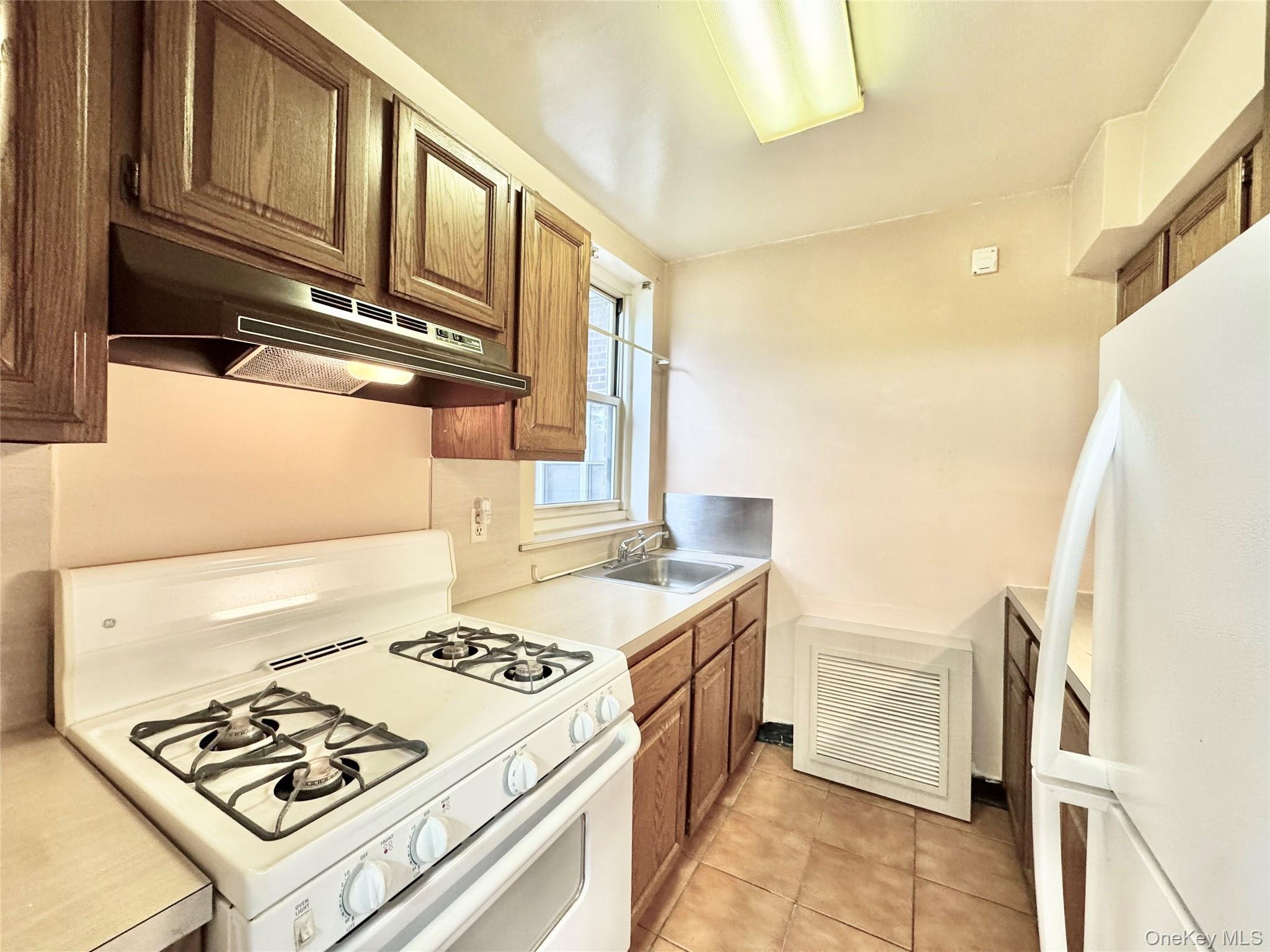 35-40 Clearview Expressway, Unit 371 Queens, NY 11361 - Photo 4 of 10 a kitchen that has a stove and a table